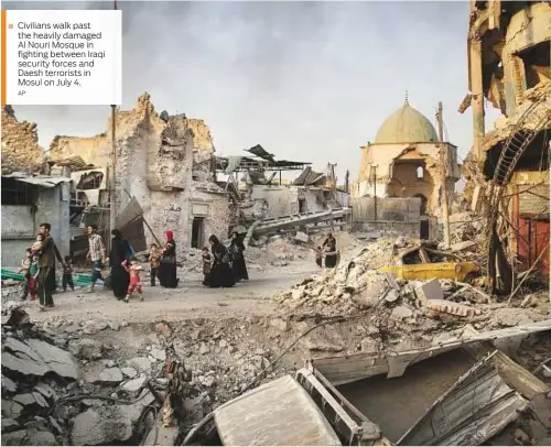  ?? AP ?? Civilians walk past the heavily damaged Al Nouri Mosque in fighting between Iraqi security forces and Daesh terrorists in Mosul on July 4.