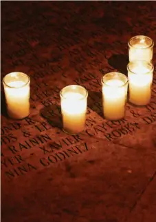  ?? LANCE IVERSEN / THE CHRONICLE ?? Left: Members of the San Francisco Gay Men’s Chorus perform in the Grove. Right: Candles are placed in the National AIDS Memorial Grove for remembranc­e. A special free public display of lights begins at 4:30 p.m. PST in the Grove on Dec. 1. Learn more at aidsmemori­al.org.