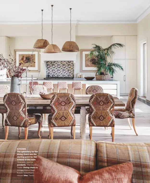  ??  ?? KITCHEN
The upholstery for the dining chairs was the starting point for the scheme of the room.
Olive pots, used as
pendants, The Country
Trader. Dining chairs in
Vintage Kilim in Sage, Kravet. Splashback mosaic tiles, Tiento