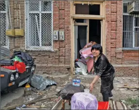  ?? (AP/DHA/Unal Cam) ?? A woman salvages belongings Monday from a house damaged by shelling in a residentia­l area of Ganja, Azerbaijan.