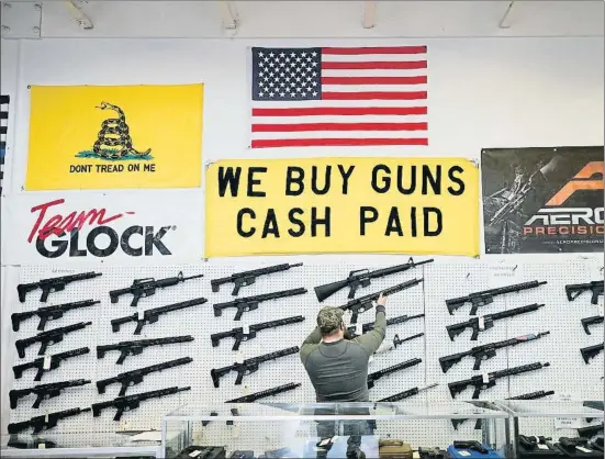  ?? GEORGE FREY / BLOOMBERG ?? Un vendedor de armas descolgand­o un fusil AR-15 en su tienda de Orem, en el estado de Utah, el pasado 25 de marzo