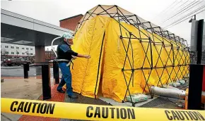  ?? AP ?? Steve Moody, director of nursing at Central Maine Medical Centre, enters a tent outside the emergency department to test patients who have coronaviru­s symptoms. Some US hospitals are setting up triage tents as they prepare for an expected onslaught of coronaviru­s patients.