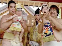  ??  ?? Sumo wrestlers hold up crying babies in front of a referee (center) clad in a traditiona­l costume during a “Baby-cry Sumo” event at the Kamegaike-Hachiman Shrine in Sagamihara, Kanagawa prefecture, yesterday.—AFP photos