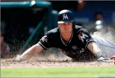  ??  ?? In this Aug. 24 file photo, Miami Marlins’ J.T. Realmuto dives into home plate with a two-run inside the park home run against the Philadelph­ia Phillies during the sixth inning of a baseball game, in Philadelph­ia, Pa. AP PHOTO