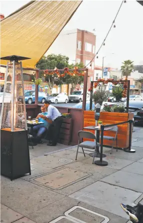  ?? Scott Strazzante / The Chronicle 2020 ?? Parklets bloomed, above, such as this one in October for the bars Sippin’ and Bottom’s Up on Mission Street. The market, left, at the Anchovy Bar restaurant in S. F.