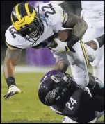  ?? Jim Young The Associated Press ?? Northweste­rn cornerback Montre Hartage tackles Michigan running back Karan Higdon in the second half of the Wolverines’ 20-17 win Saturday.