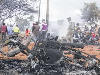  ?? Associated Press ?? Destroyed motorbikes and debris litter the scene as a victim is carried away after a gasoline tanker exploded on Saturday in Morogoro, Tanzania, one of the worst incidents of its kind in the east African country.