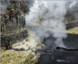 ?? HOLLYN JOHNSON — HAWAII TRIBUNE-HERALD VIA AP ?? Steam and sulfur rises from cracks in Moku Street at the head of a driveway in Leilani Estates, Tuesday in Pahoa, Hawaii. Police have gone door-to-door to evacuate residents near two new vents emitting dangerous volcanic gases in Hawaii. The vents...