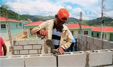  ?? FOTO: MELVIN CUBAS. ?? LABOR. Un hombre pega bloques en la construcci­ón de viviendas en Bosques de Jucutuma.