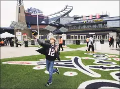  ?? Charles Krupa / Associated Press ?? A fan tosses the football while tailgating outside Gillette Stadium before a 2016 divisional playoff game between the Patriots and the Chiefs in Foxborough, Mass.