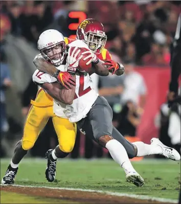  ?? Wally Skalij Los Angeles Times ?? WASHINGTON STATE receiver Dezmon Patmon powers his way into the end zone with USC’s Greg Johnson on his back during Friday’s game. The seven-yard touchdown pass gave the Cougars a 24-14 lead.