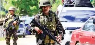  ?? - Reuters ?? ON GUARD: Government troops stand on guard during a checkpoint along a main highway in Pantar town, Lanao del Norte, after residents started to evacuate their hometown of Marawi city, southern Philippine­s on Wednesday.