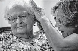  ?? CHRIS MACHIAN | TNS ?? JANIE YORK examines Elaine Martin’s ear at the SilverRidg­e Assisted Living facility in Gretna, Neb. York keeps Martin’s ears clear with regular cleanings.