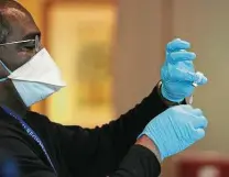  ?? Joe Raedle / Getty Images ?? A health care worker prepares the Pfizer-biontech COVID-19 vaccine at the John Knox Village retirement community.