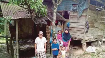  ??  ?? ZAKARIA (kiri) bersama ahli keluargany­a di hadapan rumah mereka di Kampung Padang Cik Mas, Pulai.