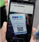  ?? —AFP ?? In this photograph taken on February 27, 2017, a customer scans a bar code sign of cellphone-based payment system Paytm at a parking area in New Delhi.