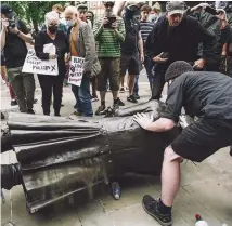  ??  ?? Bristol protesters with the fallen statue of Edward Colston. Twitter users have been debating the pros and cons of such removals