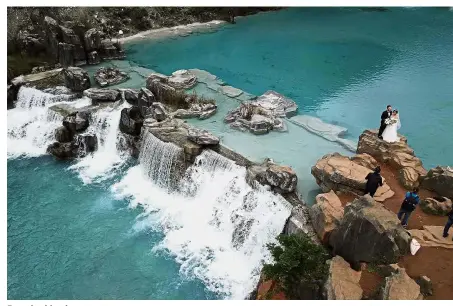  ?? — AP ?? Breathtaki­ng beauty: An aerial photo showing a couple posing for photograph­s at the Valley of the Blue Moon glacial lake fed by the Baishui Glacier No.1 atop the Jade Dragon Snow Mountain in Yunnan.