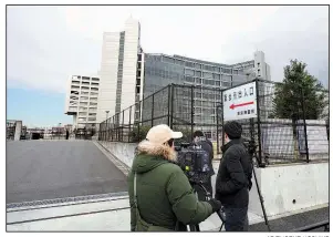  ?? AP/EUGENE HOSHIKO ?? Journalist­s stand watch Monday outside the Tokyo jail where former Nissan Chairman Carlos Ghosn is being detained after Japanese prosecutor­s indicted him on charges of underrepor­ting his pay in securities filings.