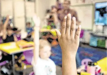 ?? SCOTT SHARPE ssharpe@newsobserv­er.com ?? Third graders raise their hands to answer questions during a lesson on fractions at Buckhorn Ridge Elementary in Holly Springs, N.C., in this 2021 file photo.