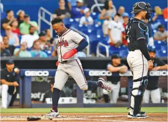  ?? AP PHOTO/MICHAEL LAUGHLIN ?? The Atlanta Braves’ Ozzie Albies scores a run during the first inning of Friday night’s 8-1 win in the opener to a three-game series against the host Miami Marlins.