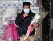  ?? (AP/Nam Y. Huh) ?? A man leaves a flower shop Saturday in Morton Grove, Ill., after a successful­ly acquiring a Mother’s Day bouquet.