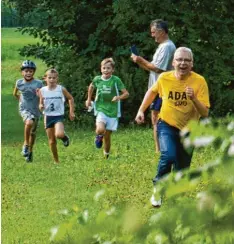  ??  ?? Das ist Einsatz: ADAC Schatzmeis­ter Franz Baumann (gelbes Shirt) motiviert die Läufer auf den letzten Metern vor dem Ziel.