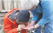  ?? PHOTO BY CAITIE MCMEKIN/NEWS SENTINEL ?? UT mycologist Karen Hughes, right, holds a white slime mold as her colleague, Brandon Matheny, takes a closer look at it at Twin Creeks Nature Center in Great Smoky Mountains National Park on Saturday.