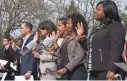  ?? MANDEL NGAN/AFP/GETTY IMAGES ?? New U.S. citizens take the oath of allegiance during a ceremony Wednesday at George Washington’s estate in Mount Vernon, Va.