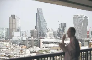  ??  ?? This file photo shows a man looking at the City of London skyline including in centre 122 Leadenhall street ‘Cheesegrat­er’ from the Tate Modern museum in central London. Chinese property investment vehicle CC Land have confirmed on March 1, that they...