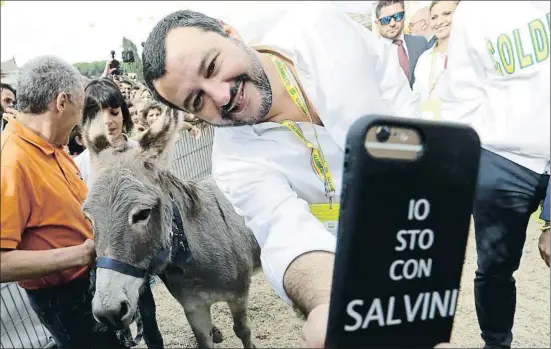  ?? ANDREW MEDICHINI / AP ?? El ministro del Interior italiano, Matteo Salvini, se toma una selfie junto a un burro en un acto sobre agricultur­a ayer en Roma