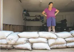  ?? GABRIELA CAMPOS/NEW MEXICAN FILE PHOTO ?? A row of sandbags lines the entrance to Vivian Romero’s garage. Romero’s Santa Fe property was severely damaged during a 2018 flood. Many residents across the county are getting involved in the efforts to update the Hazard Mitigation Plan, which assesses natural disaster risks.