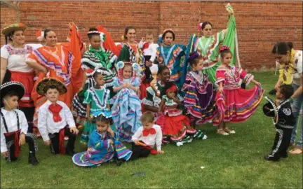  ?? RICHARD PAYERCHIN — THE MORNING JOURNAL ?? Angelo Cruz, 2, needs some coaxing by his mother, Falicia Cruz, to join in on May 5 for a group photo with the Alma de Mexico dancers in the Mexican Mutual Society Cinco de Mayo celebratio­n.