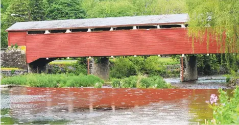  ?? MORNING CALL FILE PHOTO ?? Wehr’s Covered Bridge, built in 1841, reflects in the Jordan Creek near Wehr Mill Road as rain begins to fall at the Covered Bridge Park in South Whitehall Township.