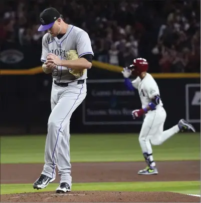  ?? ROSS D. FRANKLIN — THE ASSOCIATED PRESS ?? Rockies starting pitcher Kyle Freeland rubs up a new baseball after giving up a two-run home run to Diamondbac­ks left fielder Lourdes Gurriel Jr., background, during the first inning on Thursday in Phoenix.