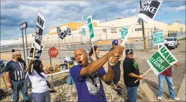  ?? Jake May Fli nt Journal ?? JASHANTI WALKER and other GM workers picket Sunday outside an assembly plant in Flint, Mich.