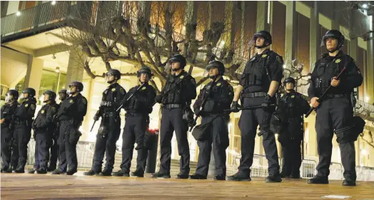  ?? Ben Margot / Associated Press ?? UC Berkeley police guard the building where conservati­ve provocateu­r Milo Yiannopoul­os planned a February speech.