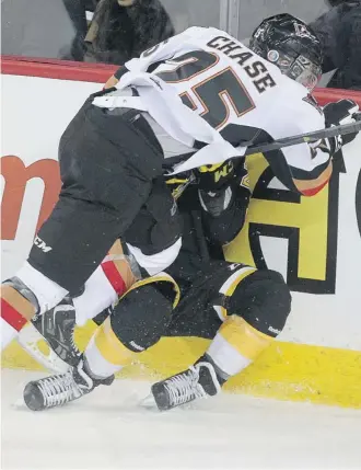  ?? Ted Rhodes/calgary Herald ?? Calgary’s Greg Chase slams Chad Robinson of the Brandon Wheat Kings into the boards behind the Brandon net during the first period Thursday night at the Scotiabank Saddledome.