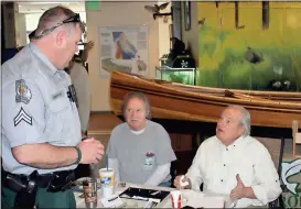  ??  ?? ABOVE: Department of Natural Resources Ranger Ben Cunningham (from left) is cajoled into buying a canoe raffle ticket by Paul Diprima and Steve Thacker.