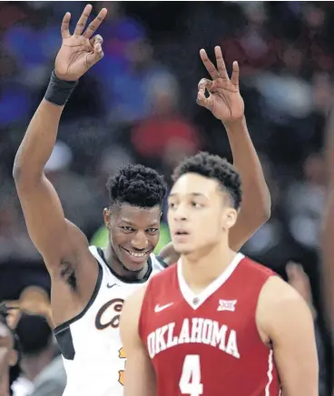  ?? [AP PHOTO] ?? Oklahoma State forward Yankuba Sima, back, celebrates behind Oklahoma center Jamuni McNeace during Wednesday’s first round of the Big 12 men’s tournament in Kansas City, Mo. Oklahoma State defeated Oklahoma 71-60.