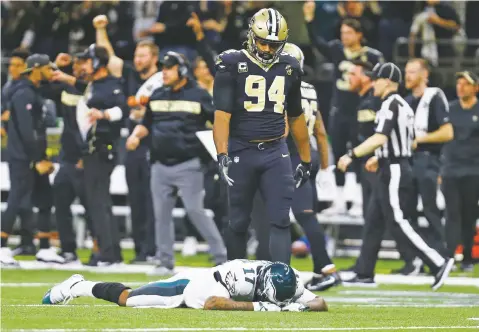  ?? BUTCH DILL/ASSOCIATED PRESS ?? Eagles wide receiver Alshon Jeffery lies on the turf in front of Saints defensive end Cameron Jordan after the Saints intercepte­d a pass in the second half of Sunday’s NFC divisional playoff game in New Orleans. The Saints won, 20-14.