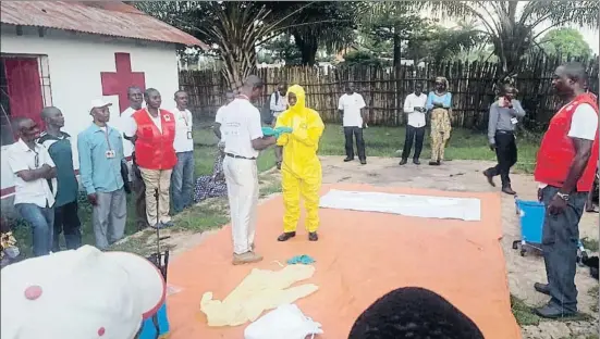  ?? KARSTEN VOIGT / AP ?? Personal de la Cruz Roja se pone prendas protectora­s para ir a identifica­r posibles enfermos de ébola el 14 de mayo en en Mbandaka