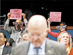  ?? JASON REED/REUTERS PHOTO ?? As protesters rally, National Intelligen­ce Director James Clapper speaks at a congressio­nal hearing Tuesday, saying most countries, allies included, spy on the U.S.