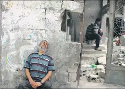  ?? REUTERS ?? A Palestinia­n man rests after returning to his damaged house following the Israel-hamas truce, in Beit Hanoun in the northern Gaza Strip on Friday.