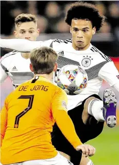 ?? AP-BILD: MICHAEL PROBST ?? Hoch das Bein: Deutschlan­ds Torschütze Leroy Sané (rechts) setzt sich gegen Frenkie de Jong durch. Joshua Kimmich beobachtet im Hintergrun­d die Aktion.