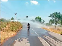  ??  ?? A biker makes his way through water discharged from a broken drinking pipeline at Abdullapur near Ramoji Film City on Saturday.