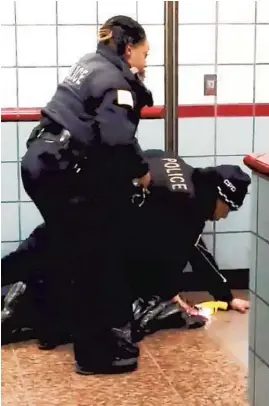  ?? MICHAEL G. MCDUNNAH ?? A video image shows Chicago police officers Melvina Bogard and Bernard Butler try to handcuff Ariel Roman at the Grand CTA Red Line station on Feb. 28, 2020.