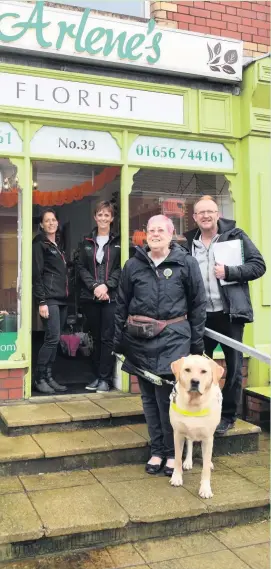  ??  ?? Buddy the guide dog at Arlene’s Florist in Kenfig Hill with owner Faith O’Sullivan, her husband Joseph, and florists Arlene and Jo