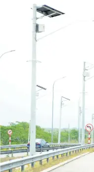  ??  ?? A section of Highway 2000 with solar-powered street lights protected by circular rings of razor-sharp prongs to deter theft of the panels.