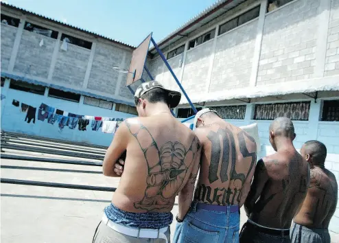  ?? ELMER MARTINEZ / AFP / GETTY IMAGES ?? Four tattooed members of the Mara Salvatruch­a MS-13 juvenile gang are imprisoned in the National Penitentia­ry in Tamara, Honduras.